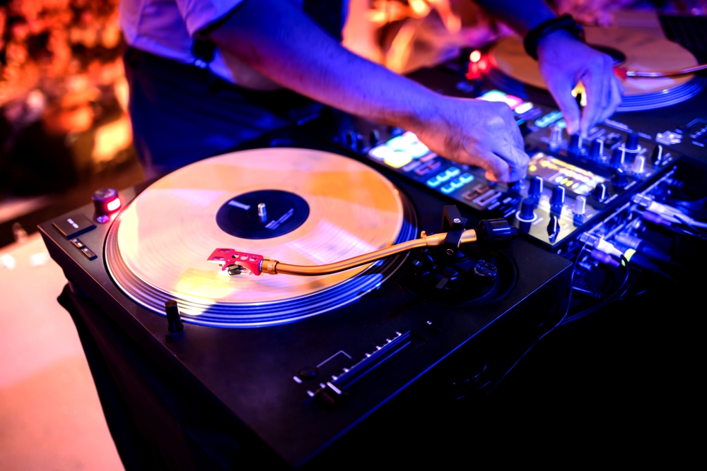A,dj,table,with,2,turntables,and,1,mixer,at